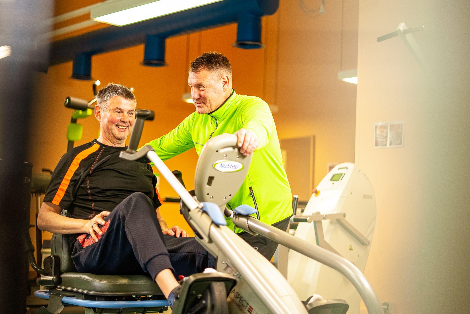 Ein Therapeut hilft einem jungen Mann bei Kraftübungen